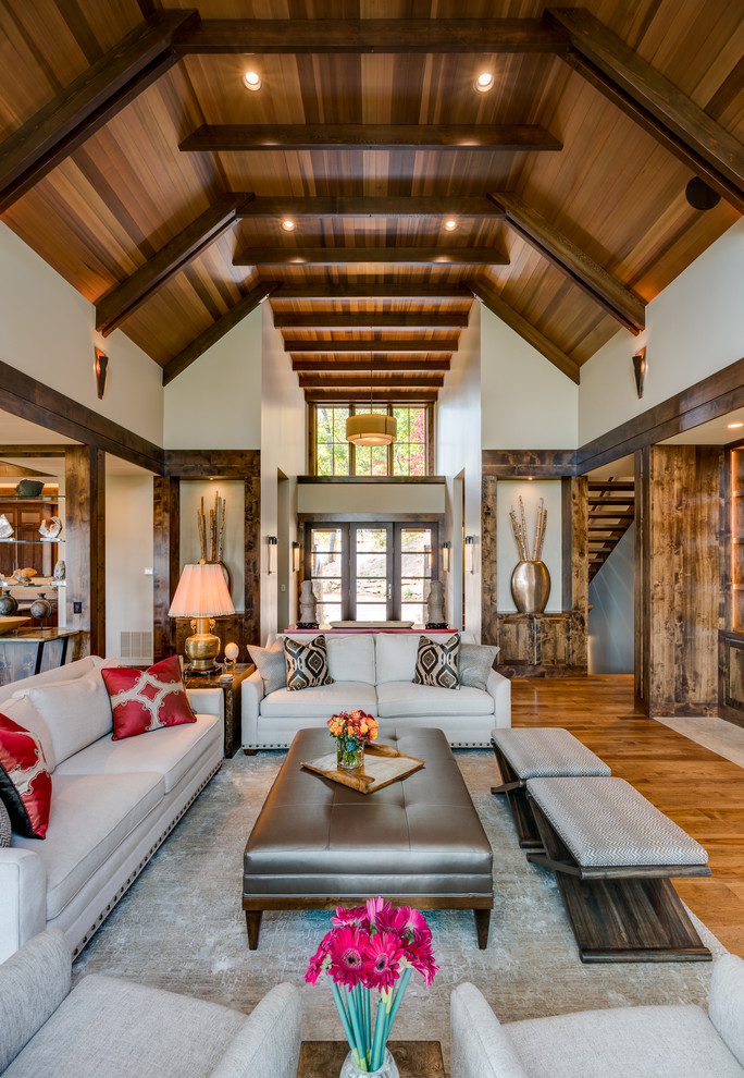 Immagine di un grande soggiorno stile rurale aperto con pareti beige e pavimento in legno massello medio