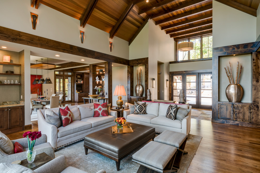 Large transitional open concept medium tone wood floor living room photo in Other with a bar, beige walls, a ribbon fireplace, a stone fireplace and a media wall
