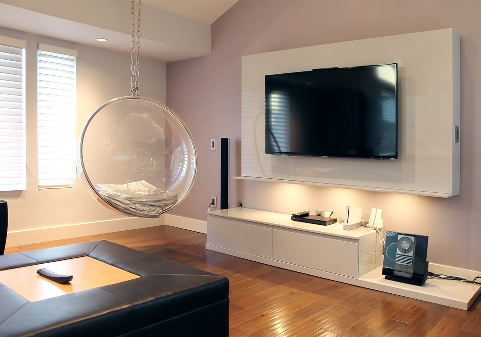 Пример оригинального дизайна: изолированная гостиная комната среднего размера в стиле модернизм с розовыми стенами, светлым паркетным полом и отдельно стоящим телевизором