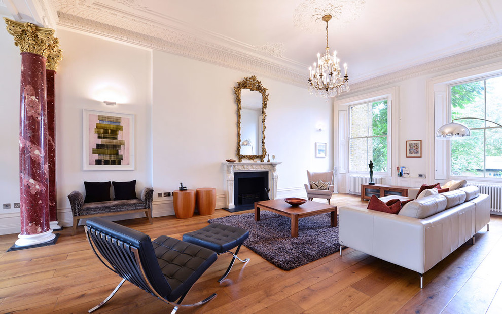 Großes, Fernseherloses, Abgetrenntes Klassisches Wohnzimmer mit weißer Wandfarbe, braunem Holzboden, Kamin, Kaminumrandung aus Stein und braunem Boden in London