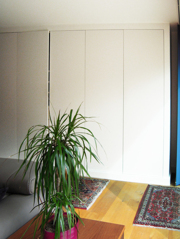 На фото: открытая гостиная комната среднего размера в современном стиле с белыми стенами и светлым паркетным полом