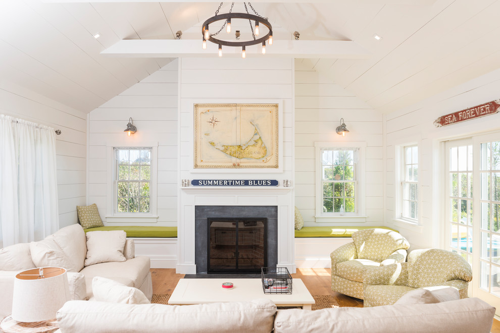 На фото: гостиная комната в морском стиле с белыми стенами, светлым паркетным полом, стандартным камином и бежевым полом без телевизора