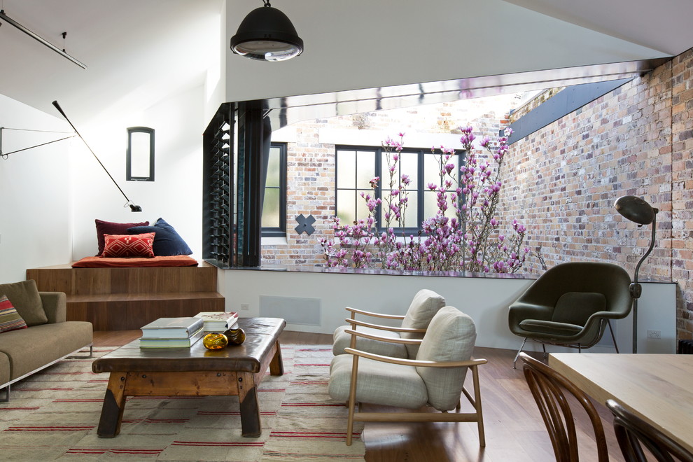 Foto de salón para visitas abierto contemporáneo de tamaño medio con paredes blancas, suelo de madera en tonos medios y suelo marrón