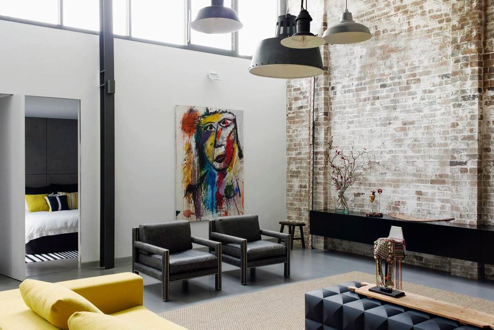 Cette image montre un grand salon urbain ouvert avec sol en béton ciré, un mur blanc, aucune cheminée, un téléviseur indépendant et un sol gris.