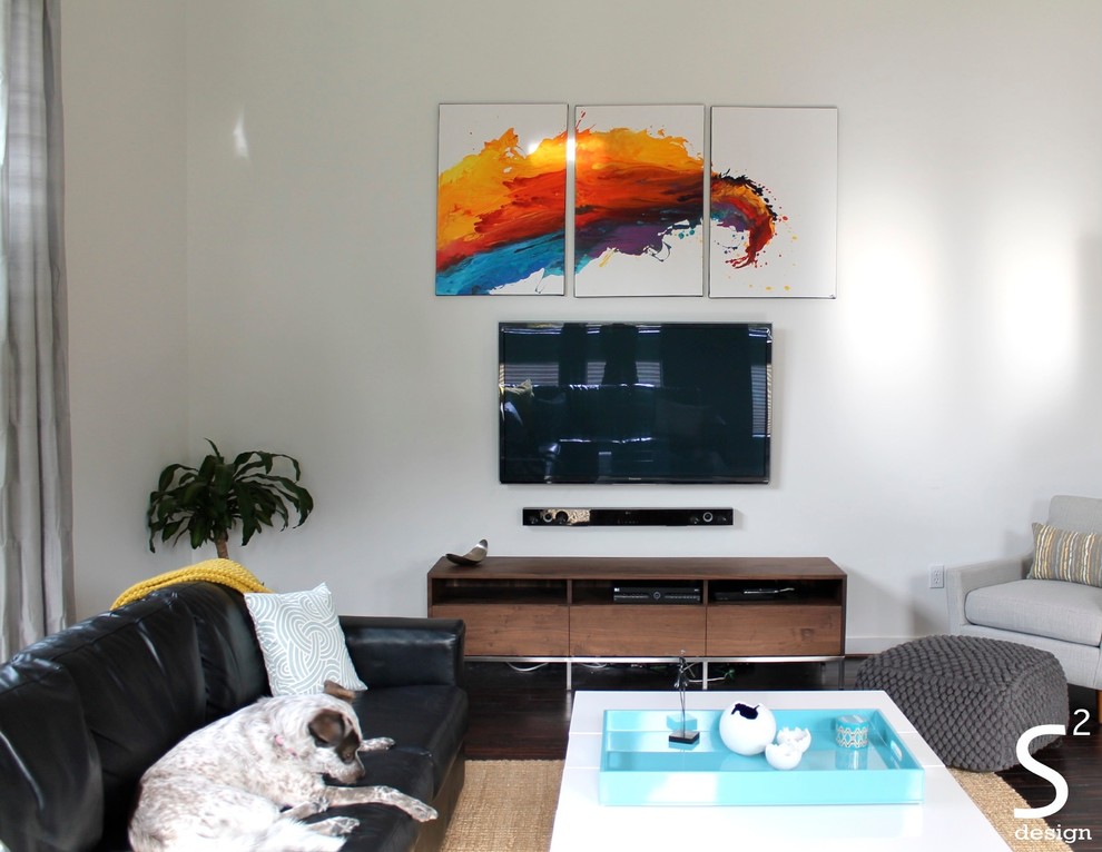 Ejemplo de salón abierto actual grande con paredes blancas, suelo de madera oscura y televisor colgado en la pared
