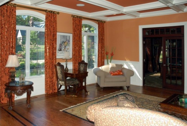 Ispirazione per un grande soggiorno tradizionale chiuso con pareti arancioni, pavimento in legno massello medio e pavimento marrone