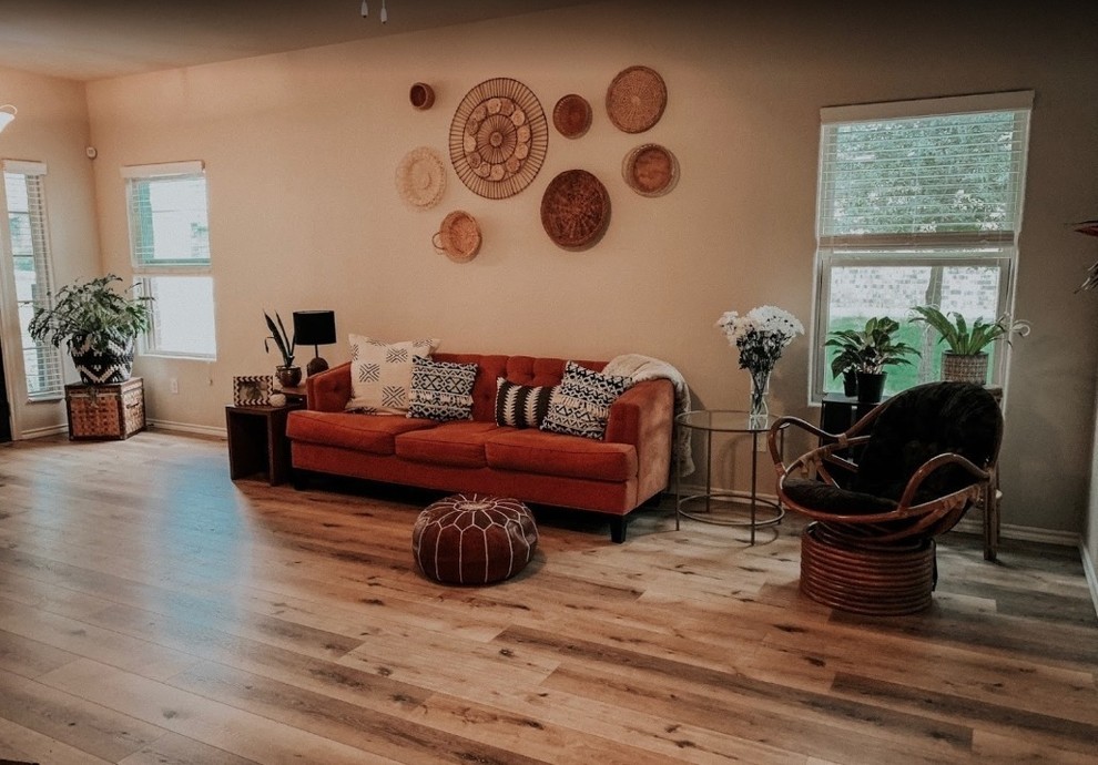 Photo of a large eclectic open plan living room in Dallas with beige walls, vinyl flooring and brown floors.