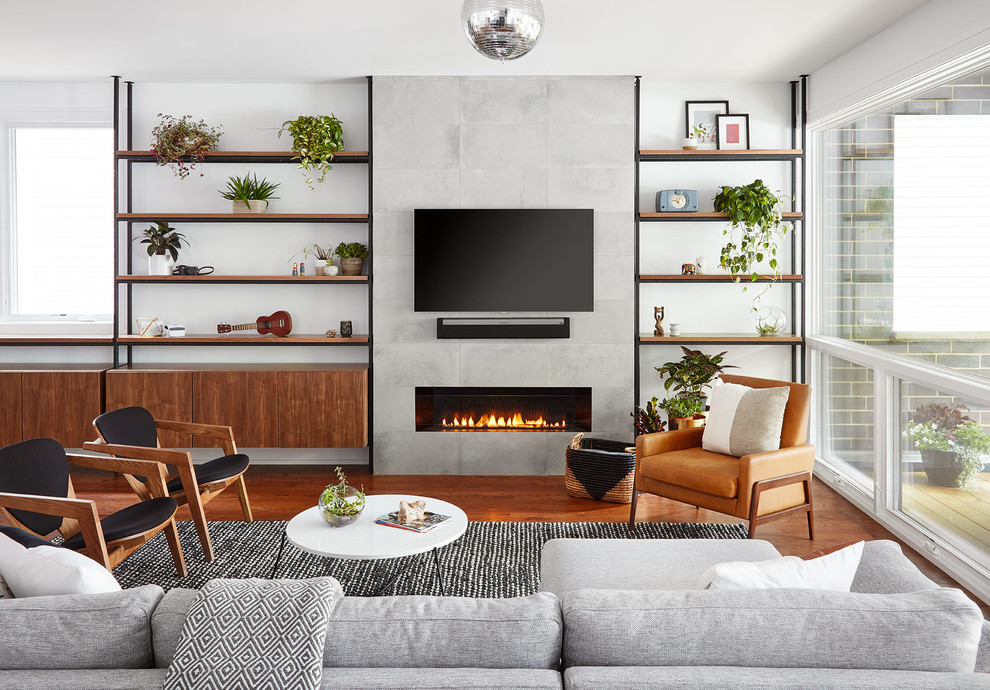 Inspiration pour un salon design avec un mur blanc, un sol en bois brun, une cheminée ribbon, un manteau de cheminée en carrelage, un téléviseur fixé au mur et un sol marron.
