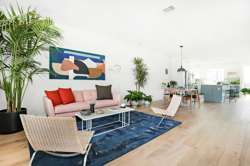 Contemporary open plan living room in Los Angeles with white walls, light hardwood flooring and brown floors.