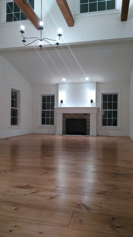 Inspiration for a medium sized country formal open plan living room in DC Metro with beige walls, medium hardwood flooring, a standard fireplace, a brick fireplace surround, no tv and brown floors.