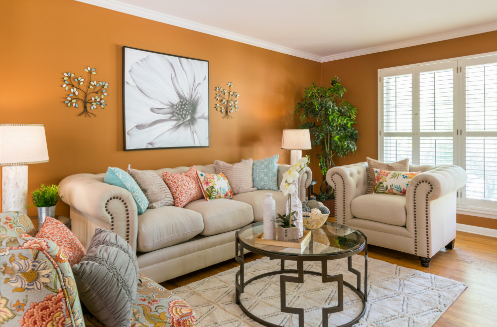 Свежая идея для дизайна: гостиная комната в стиле неоклассика (современная классика) с оранжевыми стенами, паркетным полом среднего тона и коричневым полом - отличное фото интерьера