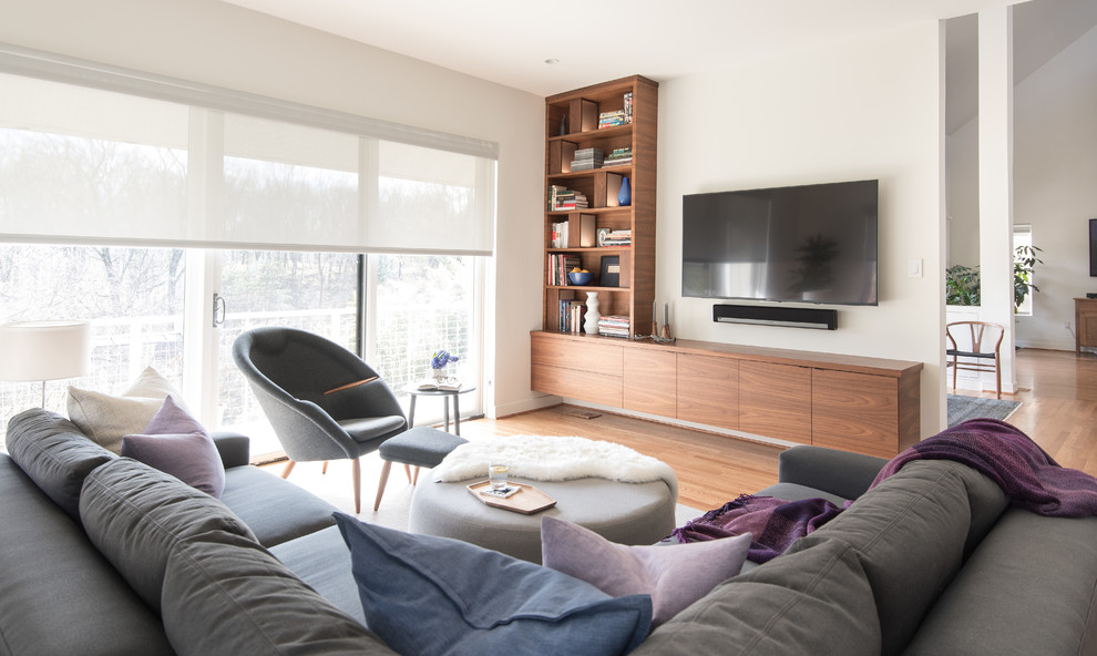 Imagen de salón tipo loft minimalista grande con suelo de madera clara y televisor colgado en la pared