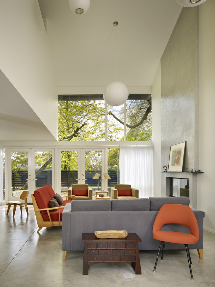 Foto di un soggiorno moderno con pareti bianche, pavimento in cemento e camino classico
