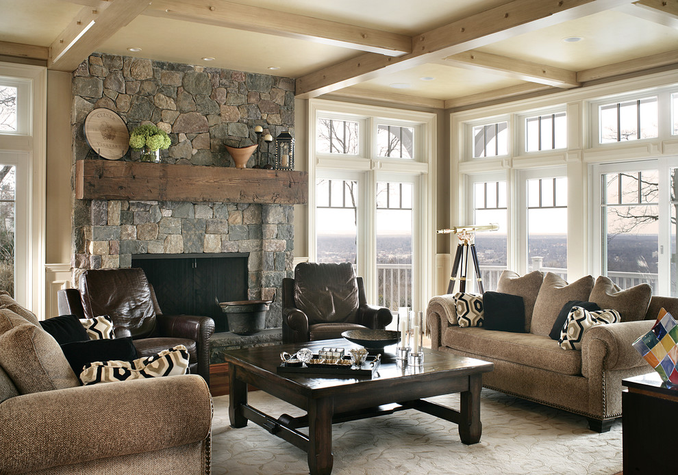 На фото: изолированная гостиная комната в классическом стиле с бежевыми стенами, фасадом камина из камня и коричневым диваном с
