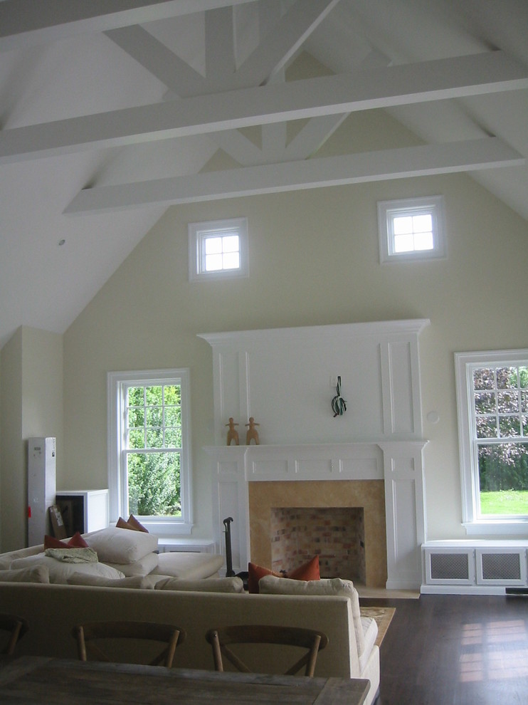 Imagen de salón abierto tradicional con paredes beige, suelo de madera oscura, todas las chimeneas y marco de chimenea de madera