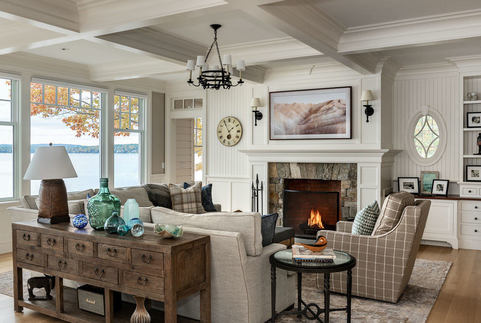 Repräsentatives, Fernseherloses Maritimes Wohnzimmer mit weißer Wandfarbe, hellem Holzboden, Kamin und Kaminumrandung aus Stein in Boston