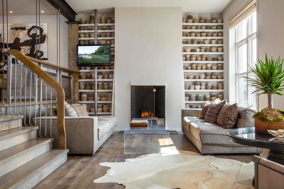 Diseño de salón contemporáneo sin televisor con paredes beige, suelo de madera en tonos medios y marco de chimenea de yeso