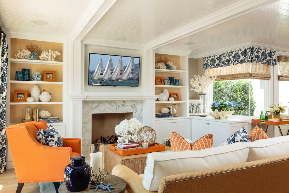 オレンジカウンティにあるラグジュアリーな広いビーチスタイルのおしゃれなLDK (グレーの壁、淡色無垢フローリング、標準型暖炉、タイルの暖炉まわり、壁掛け型テレビ) の写真