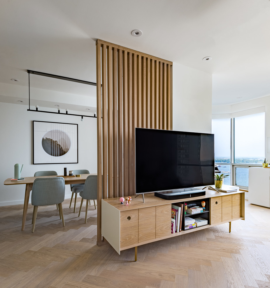 This is an example of a small scandinavian open plan living room in Toronto with white walls, light hardwood flooring and a freestanding tv.