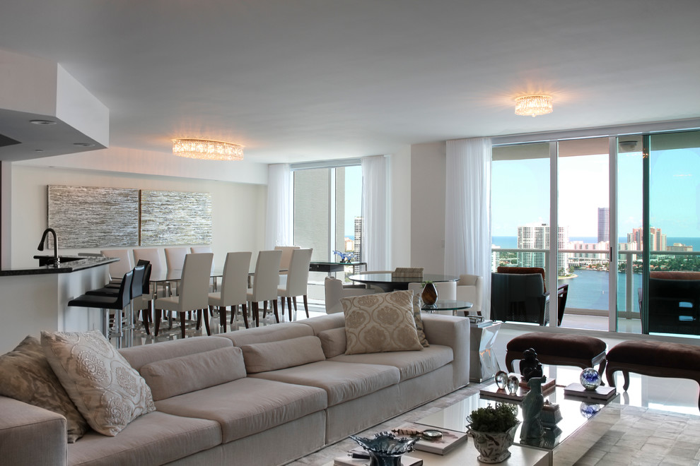 This is an example of a large contemporary formal open plan living room in Miami with marble flooring and beige walls.