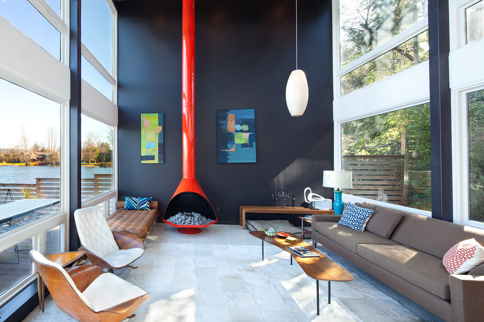 Пример оригинального дизайна: открытая гостиная комната в стиле ретро с черными стенами и коричневым диваном без телевизора