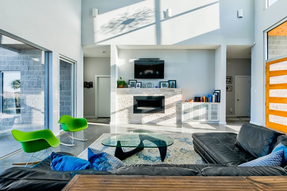 Стильный дизайн: гостиная комната в стиле неоклассика (современная классика) с серыми стенами, горизонтальным камином, фасадом камина из камня, телевизором на стене и серым полом - последний тренд