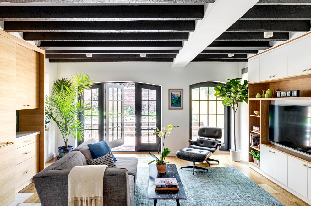 Offenes Modernes Wohnzimmer ohne Kamin mit Multimediawand, weißer Wandfarbe, braunem Holzboden, braunem Boden und freigelegten Dachbalken in New York