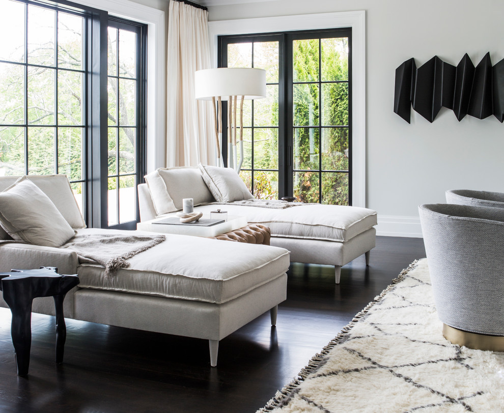 На фото: гостиная комната в стиле неоклассика (современная классика) с серыми стенами, темным паркетным полом и красивыми шторами с