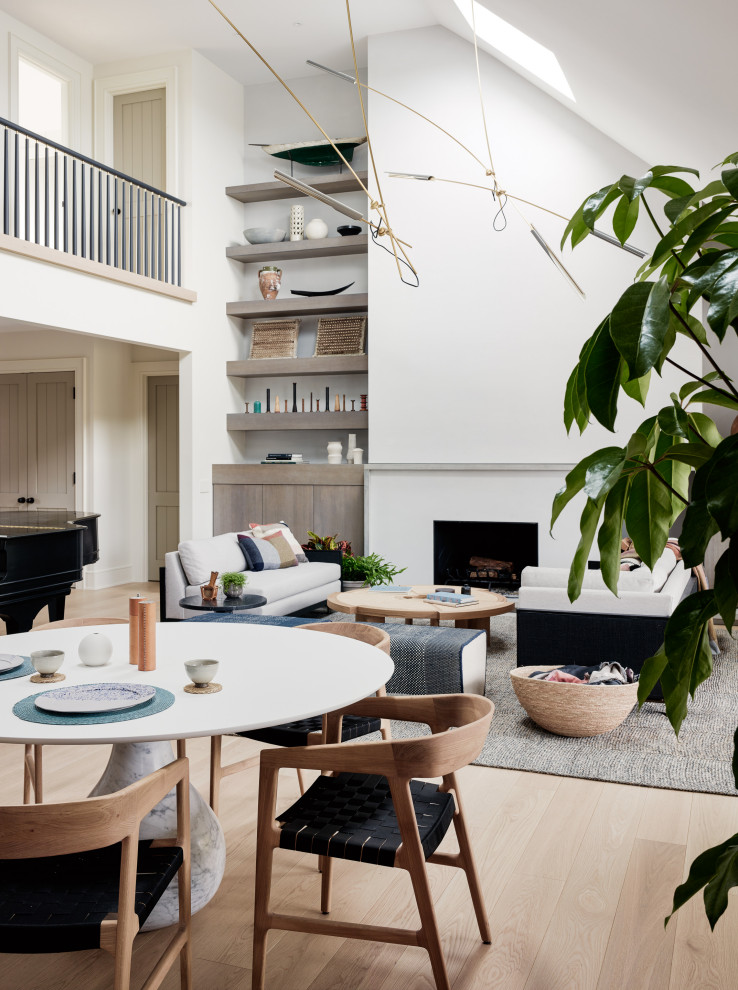 Aménagement d'un salon contemporain ouvert avec un mur blanc, parquet clair, une cheminée standard et un sol beige.
