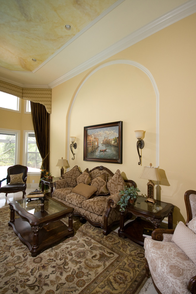 Стильный дизайн: открытая гостиная комната в морском стиле с желтыми стенами, мраморным полом, стандартным камином, фасадом камина из штукатурки и бежевым полом - последний тренд