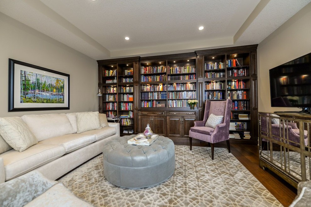 Immagine di un soggiorno chic di medie dimensioni e chiuso con libreria, pareti beige, parquet scuro e TV autoportante