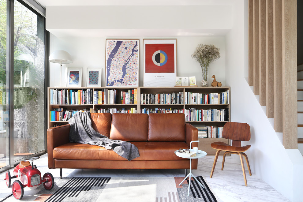 Immagine di un soggiorno moderno aperto con libreria, pareti bianche e pavimento grigio