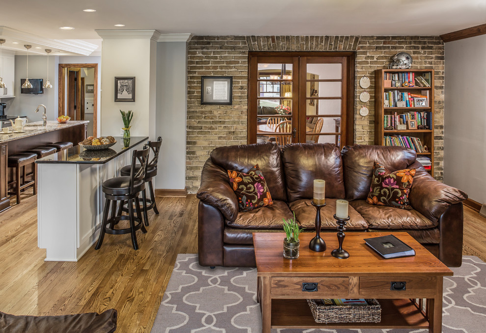Immagine di un soggiorno classico di medie dimensioni e aperto con libreria, pareti marroni, pavimento in legno massello medio, TV a parete e pavimento marrone