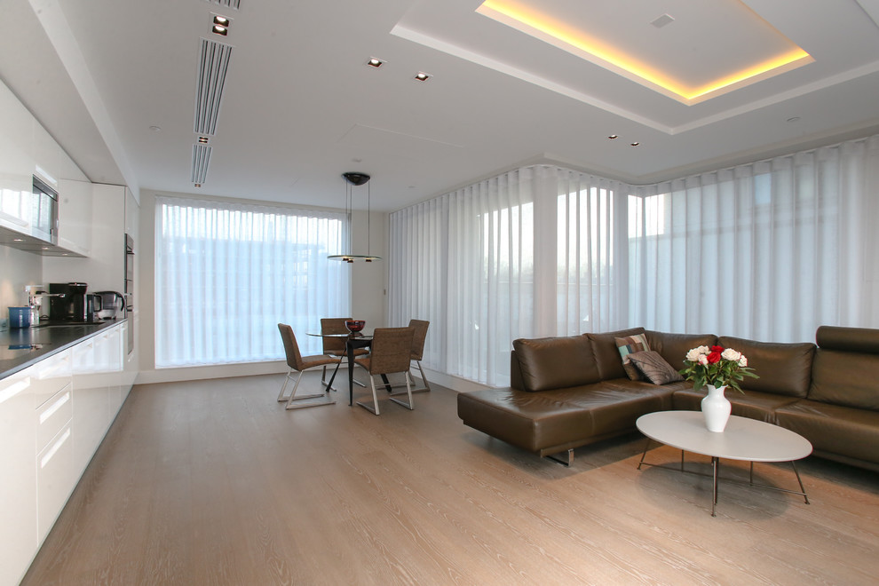 Inspiration for a contemporary living room in London with beige walls and medium hardwood flooring.