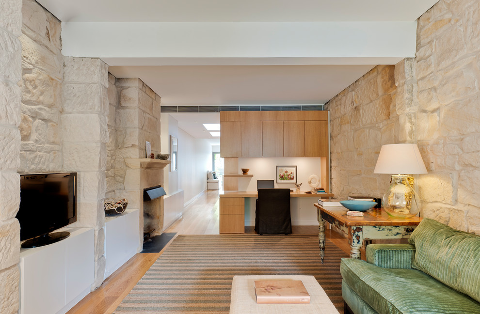Esempio di un soggiorno design con parquet chiaro, pareti beige, TV autoportante e pavimento marrone
