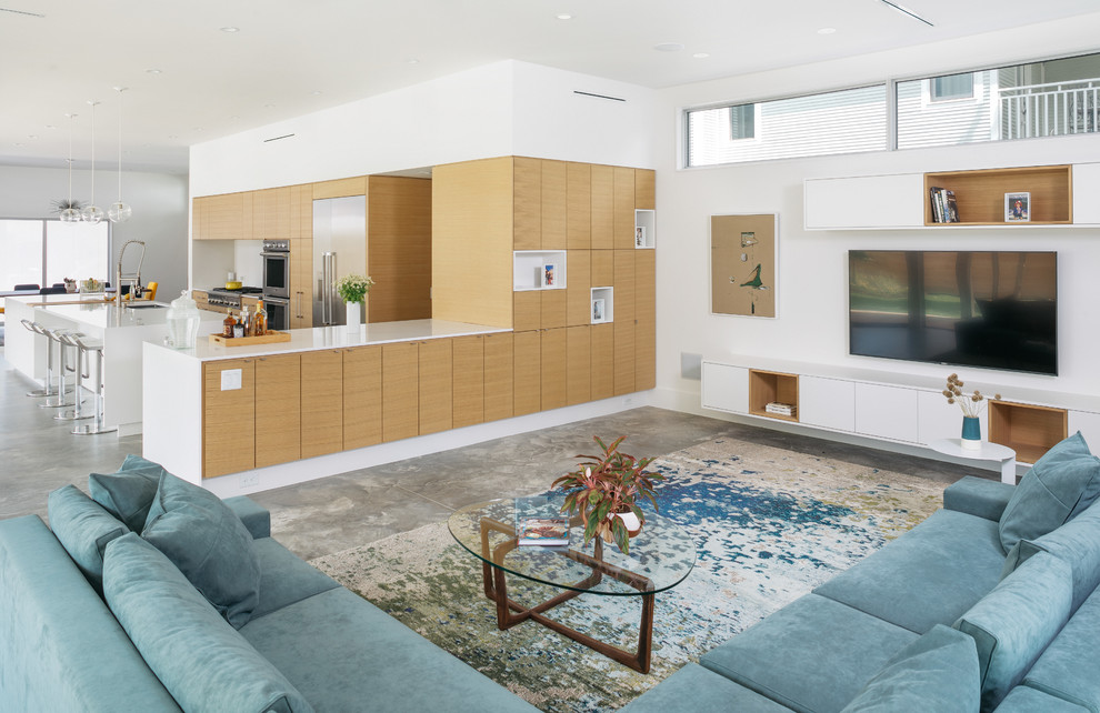 Esempio di un soggiorno minimalista di medie dimensioni e aperto con pareti bianche, pavimento in cemento, TV a parete e pavimento grigio