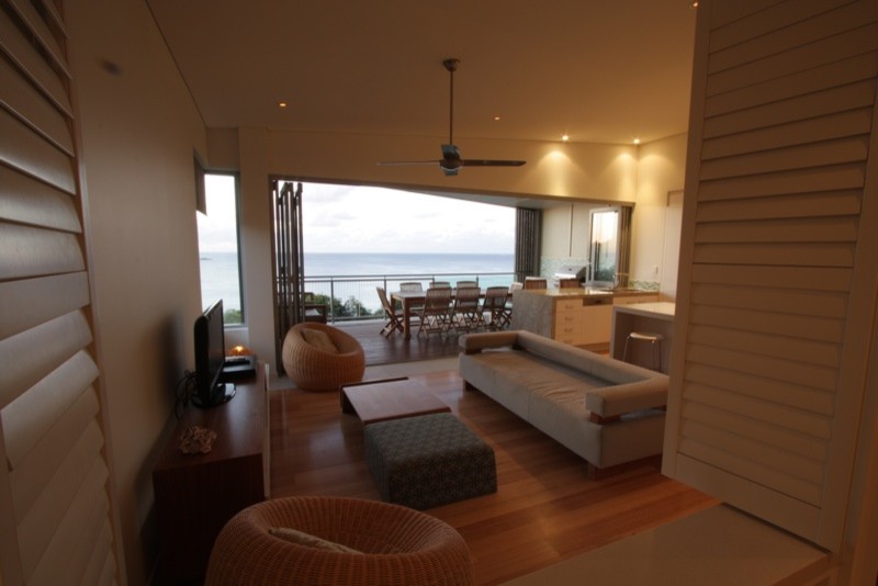 Immagine di un soggiorno costiero di medie dimensioni e aperto con TV autoportante, pareti bianche e parquet chiaro