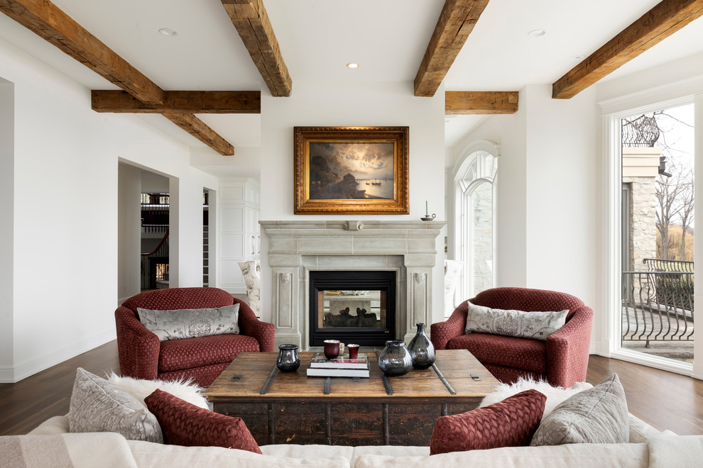 Foto de salón abierto clásico con paredes blancas, suelo de madera en tonos medios, chimenea de doble cara, marco de chimenea de piedra y suelo marrón