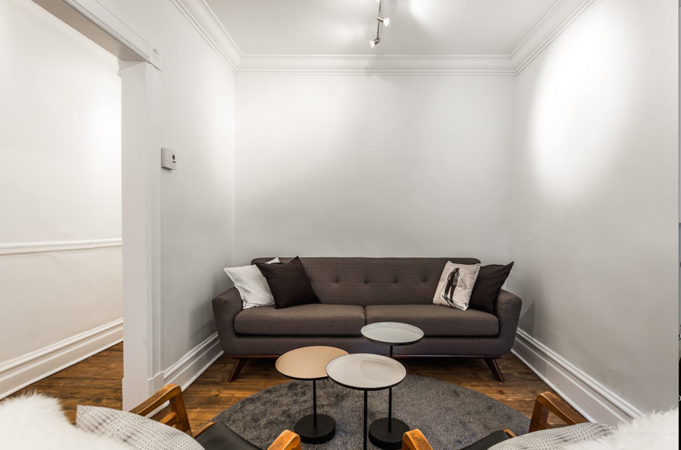 Идея дизайна: маленькая изолированная гостиная комната в стиле ретро с белыми стенами, паркетным полом среднего тона и коричневым полом без камина для на участке и в саду