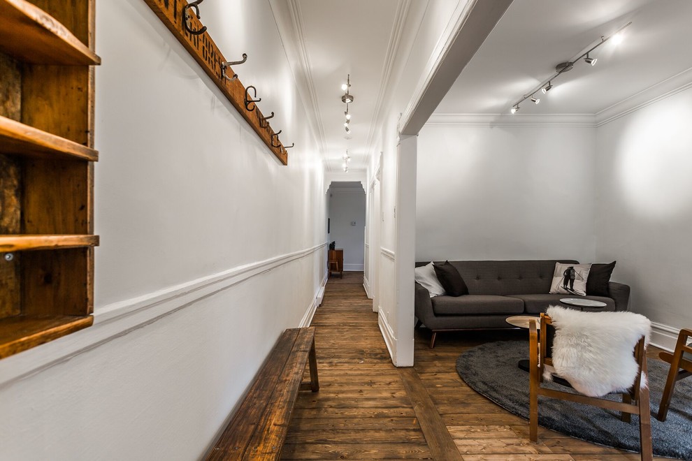 モントリオールにあるお手頃価格の小さなミッドセンチュリースタイルのおしゃれな独立型リビング (白い壁、無垢フローリング、暖炉なし、茶色い床) の写真