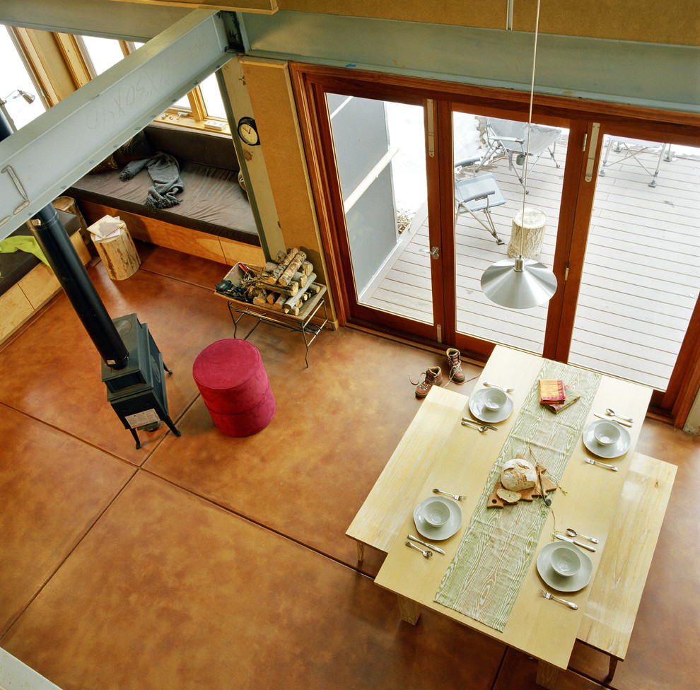 Exemple d'un petit salon moderne ouvert avec un mur beige, sol en béton ciré, un poêle à bois et aucun téléviseur.