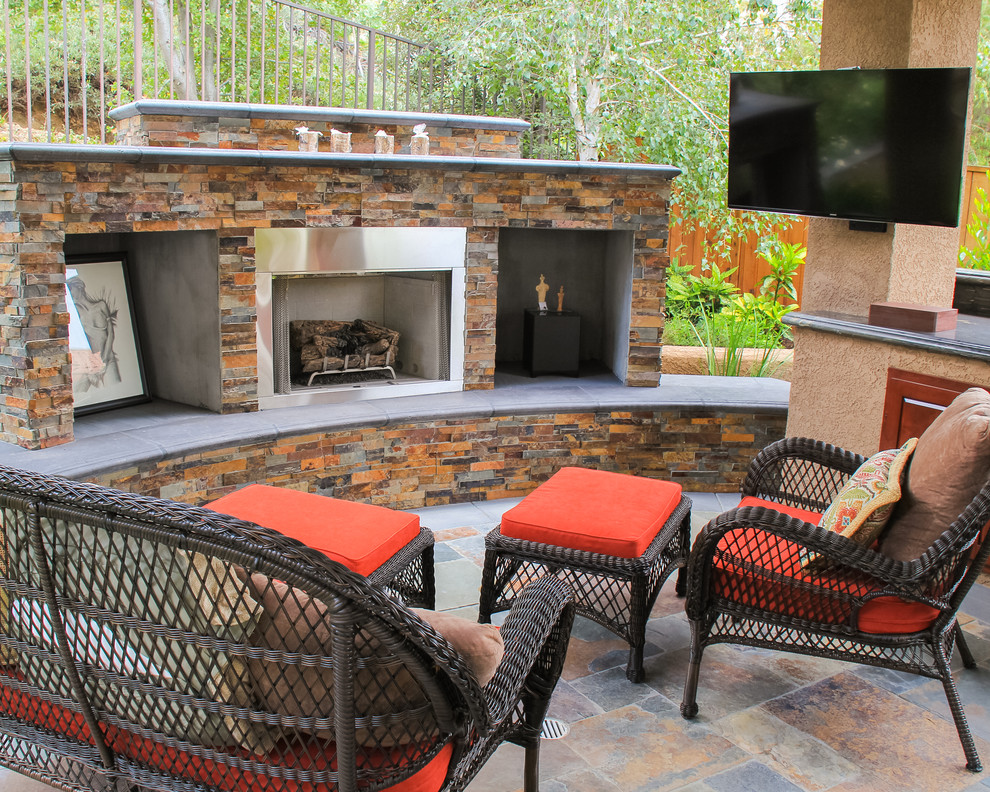 Example of a mid-sized eclectic open concept concrete floor living room design in Orange County with beige walls, a standard fireplace, a stone fireplace and a wall-mounted tv