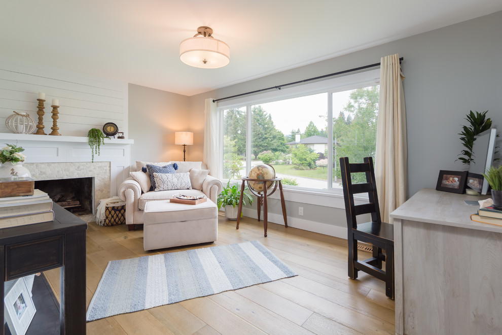 Idée de décoration pour un salon minimaliste de taille moyenne et ouvert avec un mur gris, un sol en bois brun, un téléviseur encastré et une cheminée standard.