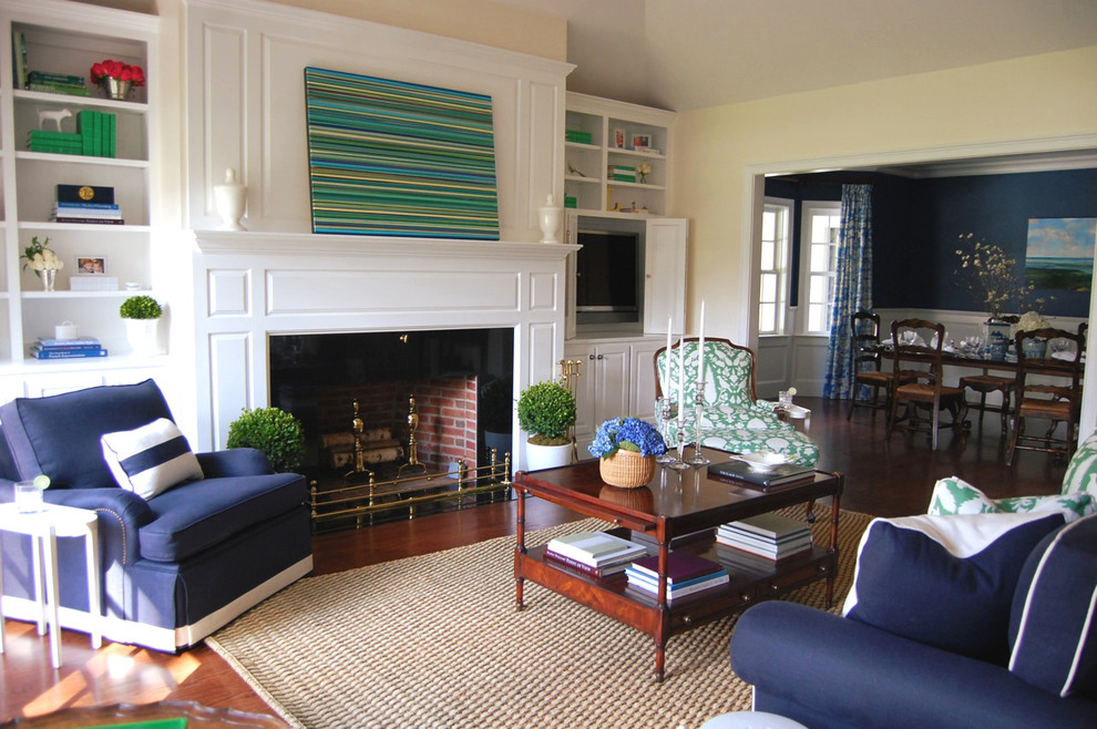 Example of a mid-sized classic formal and open concept medium tone wood floor living room design in Boston with yellow walls, a standard fireplace, a wood fireplace surround and a media wall