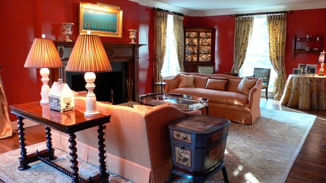 Пример оригинального дизайна: парадная, изолированная гостиная комната среднего размера в классическом стиле с красными стенами, темным паркетным полом, стандартным камином и коричневым полом без телевизора
