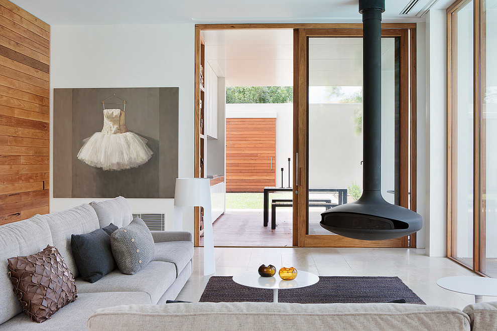 This is an example of a modern formal living room in Melbourne with white walls and a hanging fireplace.