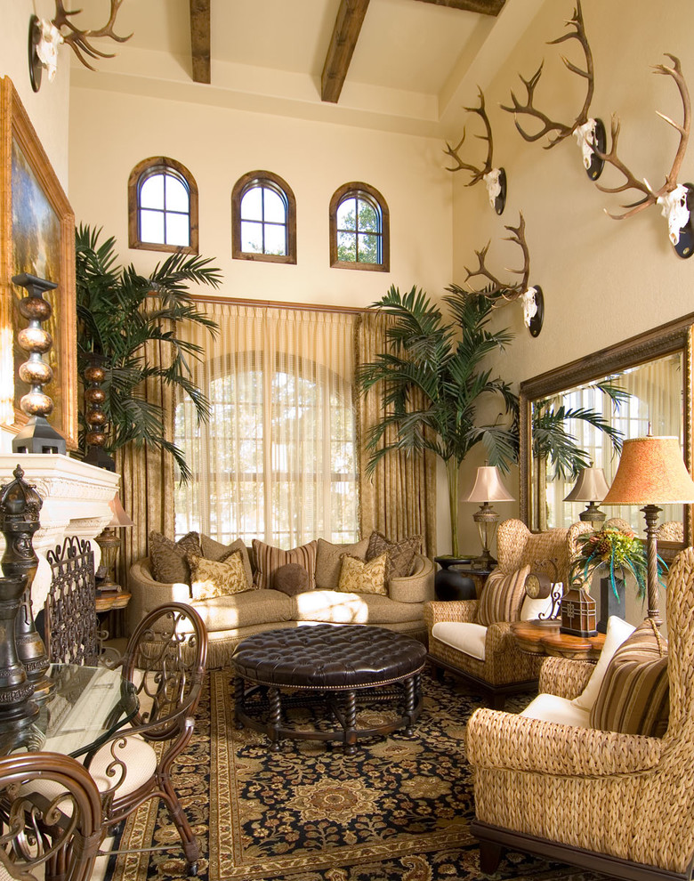 На фото: большая гостиная комната в средиземноморском стиле с бежевыми стенами и стандартным камином с