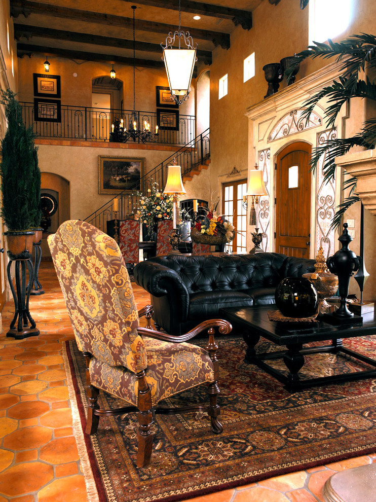 На фото: большая открытая гостиная комната в средиземноморском стиле с бежевыми стенами и полом из терракотовой плитки