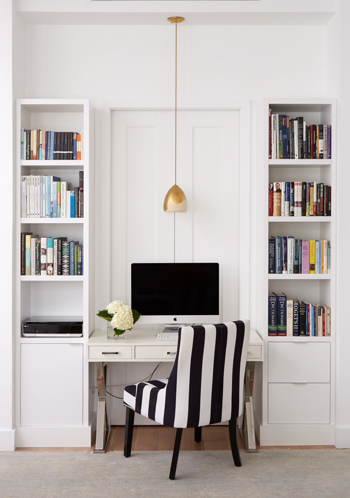 Ejemplo de biblioteca en casa tipo loft contemporánea de tamaño medio con paredes blancas, suelo de madera clara, televisor colgado en la pared y suelo beige
