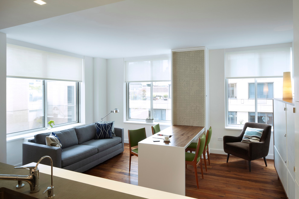 This is an example of a small modern living room in New York with white walls and medium hardwood flooring.